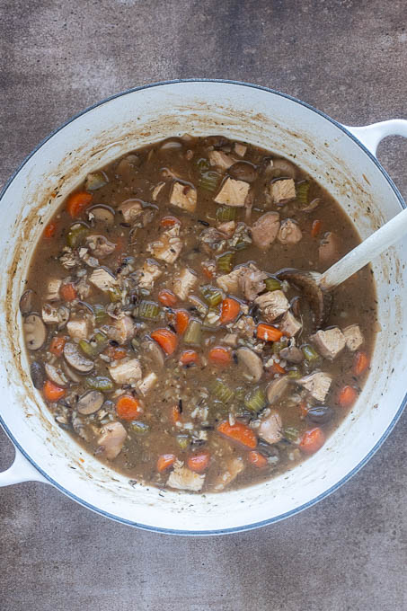 Chicken and wild rice soup in pot with chopped chicken breast.