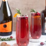 Poinsettia Cocktails garnished with cranberries and orange twist.
