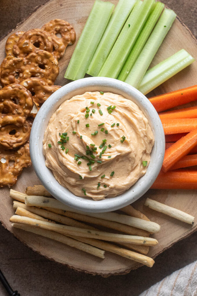 Cheddar pub cheese in a bowl topped with chopped chives.