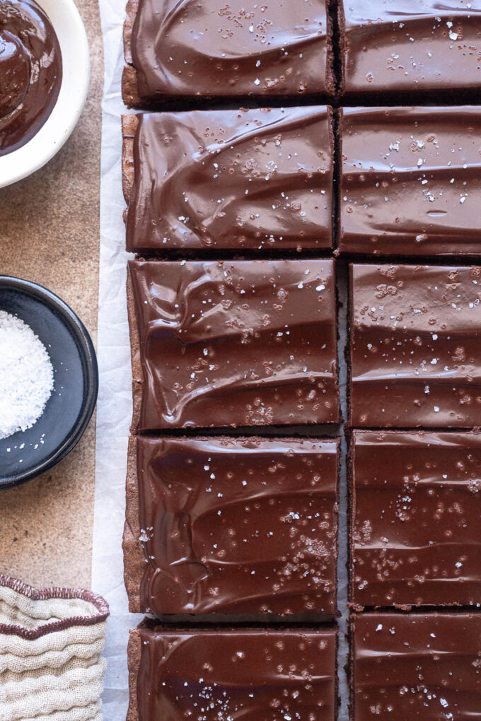 Cocoa brownies with chocolate ganache sliced cleanly into squares.