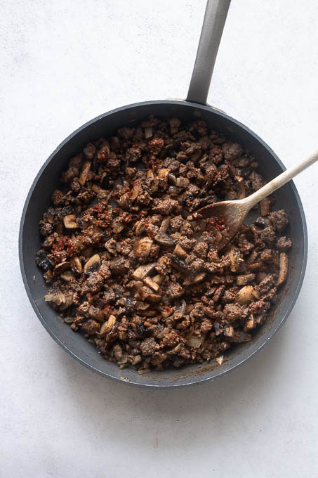 Saute aromatics, ground beef and tomato paste for spaghetti squash casserole.