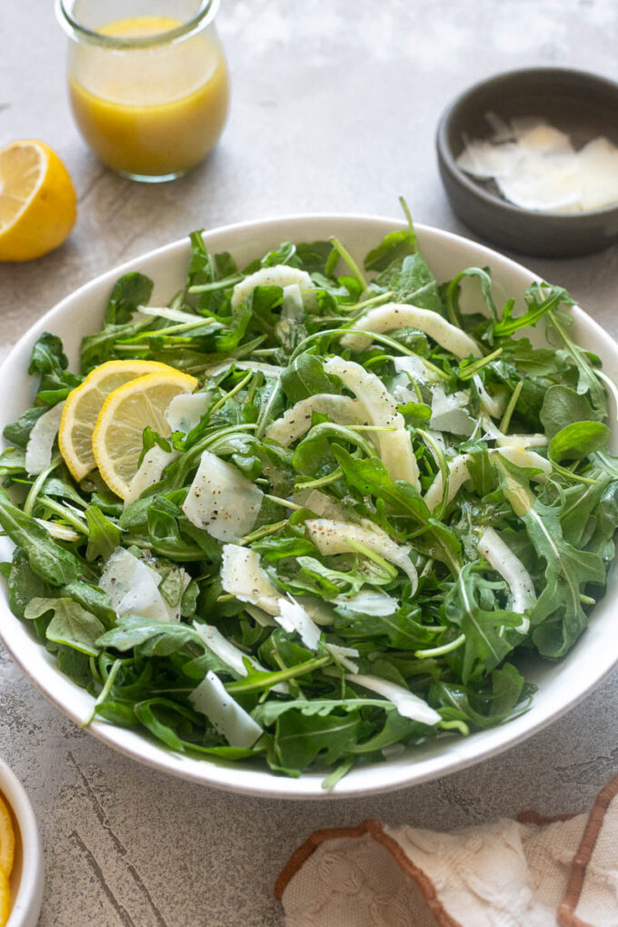 Shaved fennel salad with arugula and parmesan in a bowl.