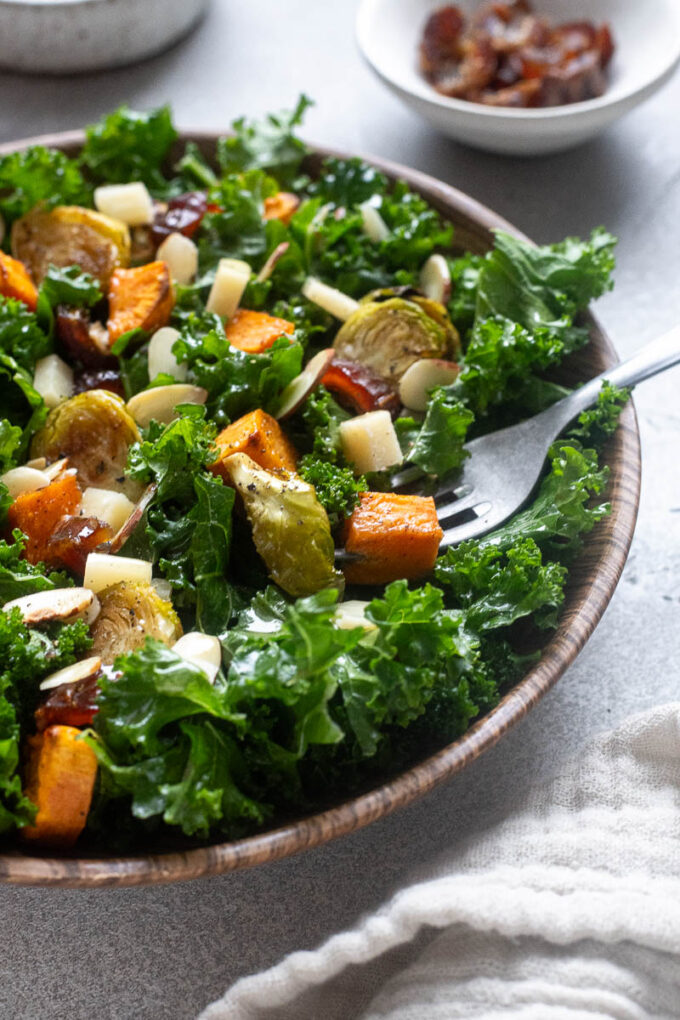Winter kale salad with sweet potatoes and brussels sprouts in a bowl.
