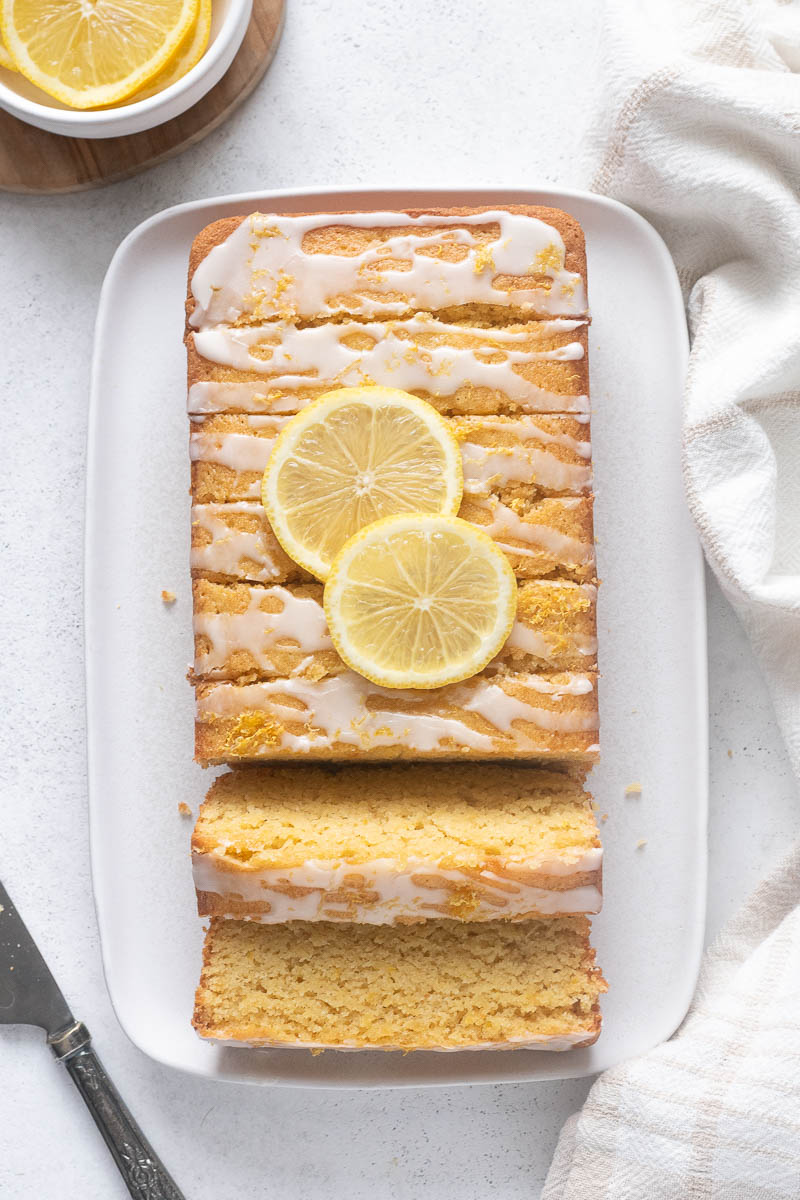 Almond flour lemon loaf cake sliced on a serving platter.