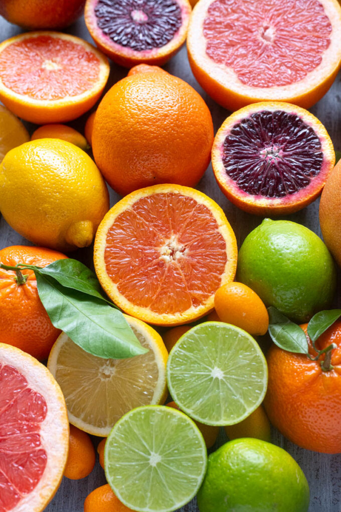 Sliced citrus fruits including blood oranges, grapefruit, lemons and limes showing vibrant interiors.