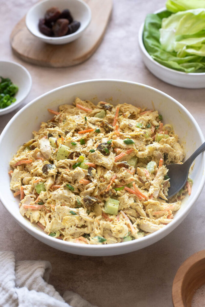 Creamy curry chicken salad with serving spoon digging in.