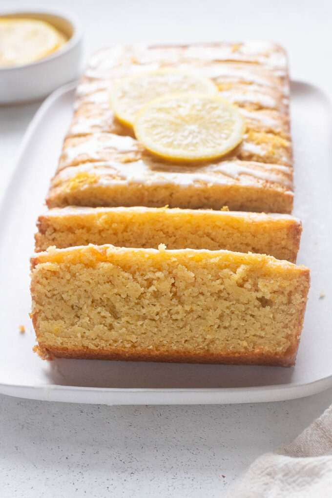 Lemon loaf with almond flour sliced on a platter.