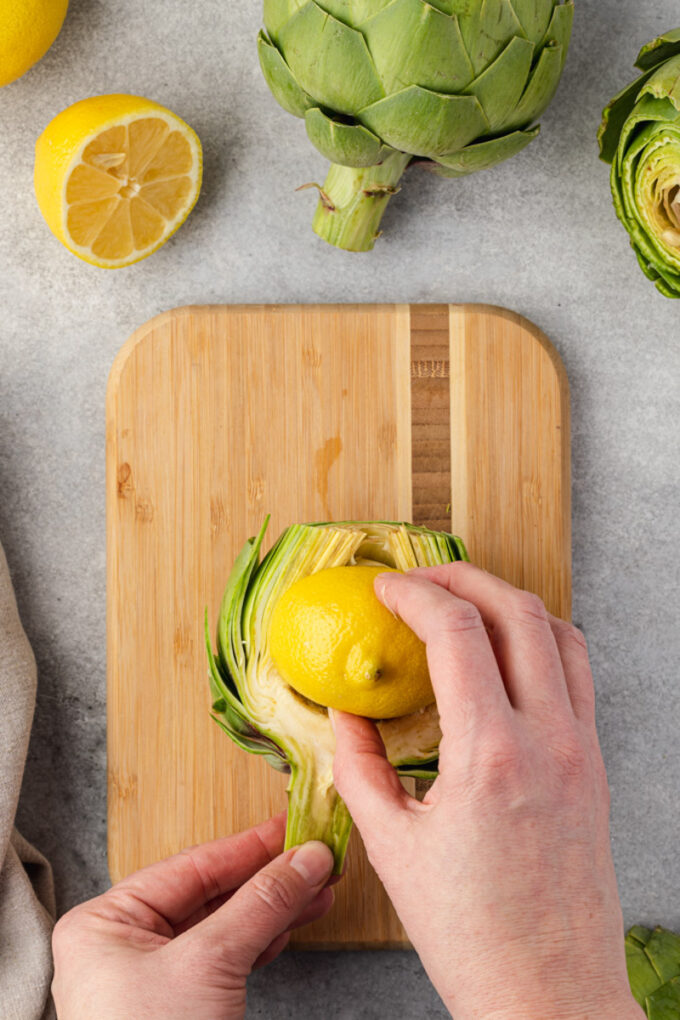 Rubbing lemon on cut artichoke to prevent browning.