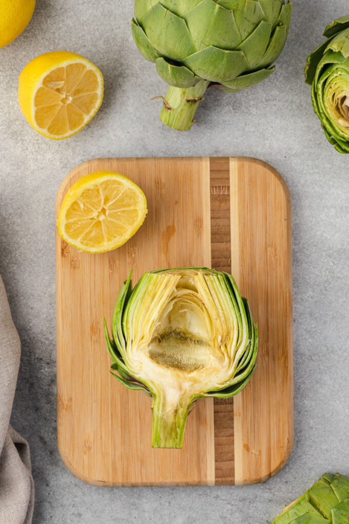 Halved artichoke with choke removed showing artichoke heart.