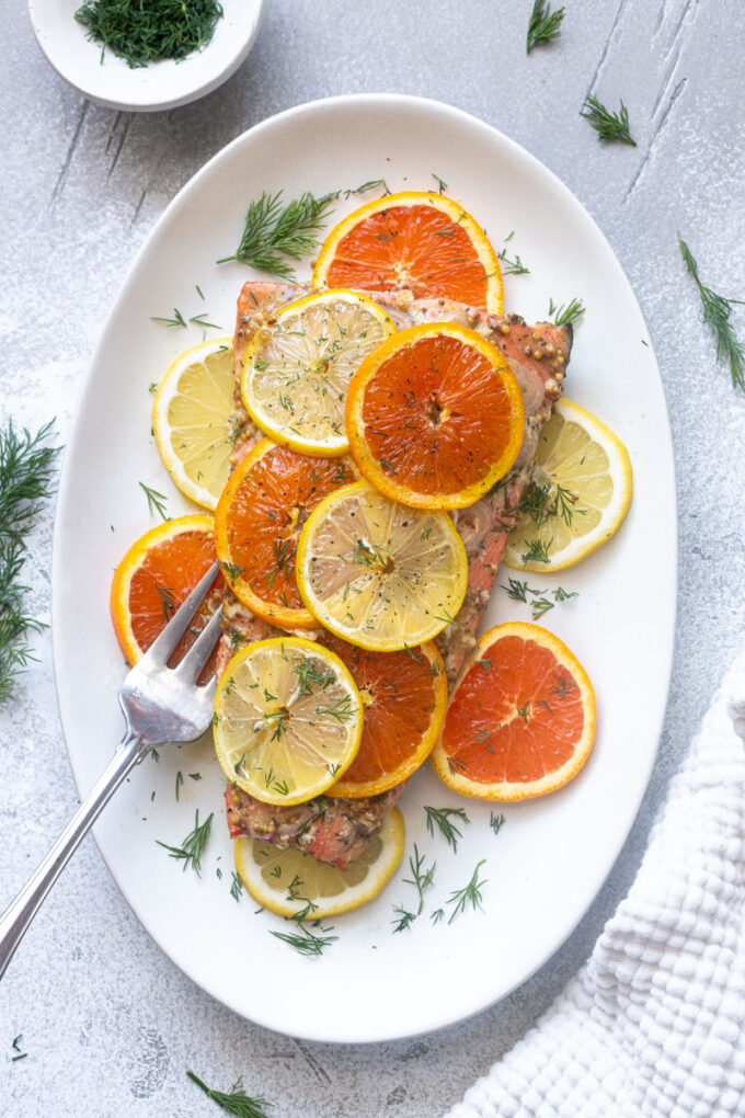 Overhead view of baked citrus salmon with Dijon, lemon and orange.
