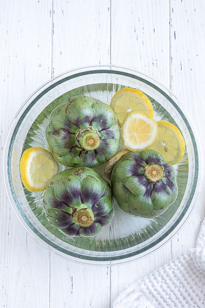 Prepped fresh artichokes in lemon water.
