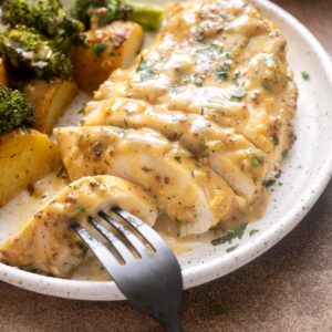 Plated honey mustard chicken with roasted potatoes and broccoli.