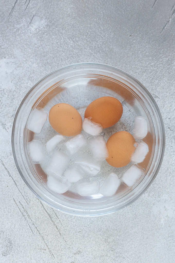 Air fryer hard boiled eggs in bowl of ice water.