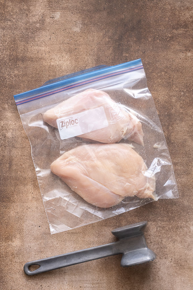 Chicken breasts pounded to even thickness in a zip top bag.