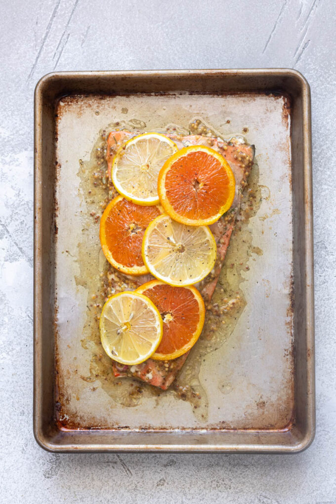 Juicy slow roasted citrus salmon on a baking sheet.