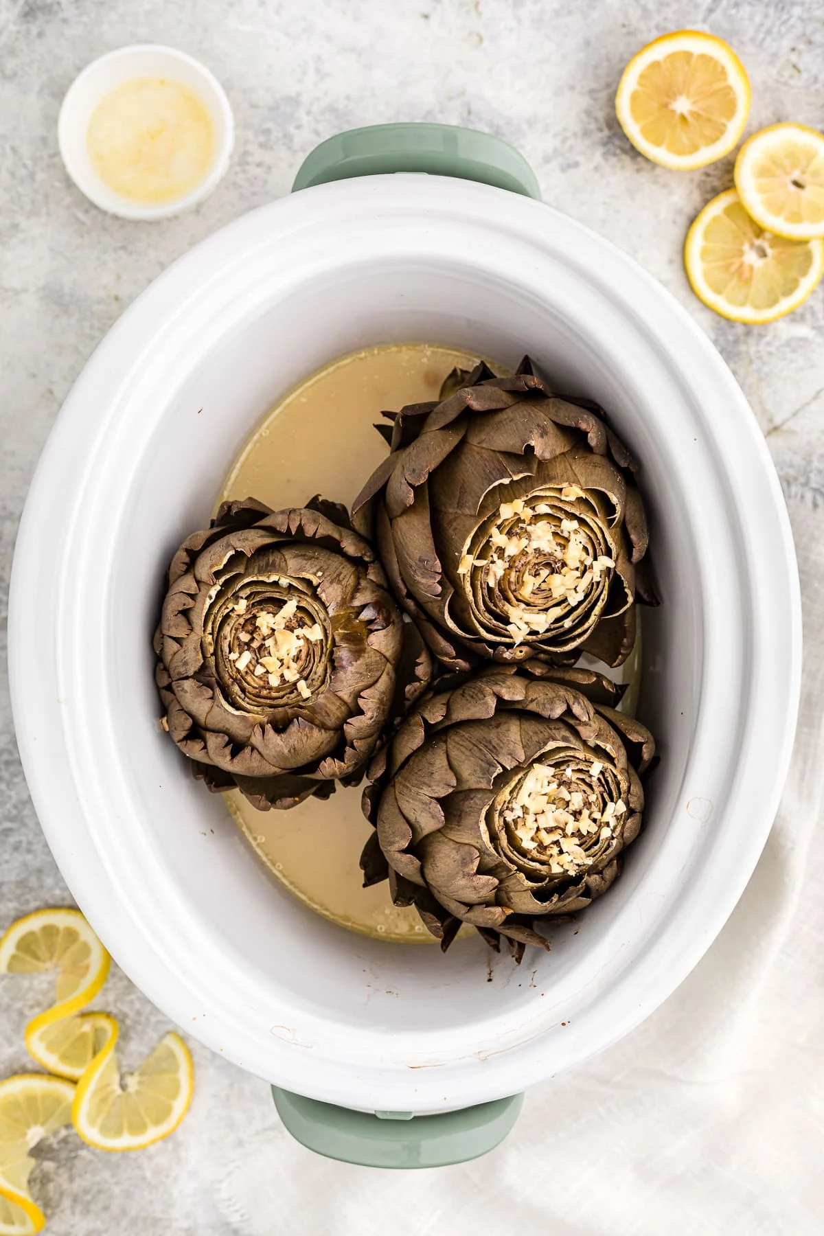 Slow cooker garlic lemon butter artichokes by the Magical Slow Cooker.
