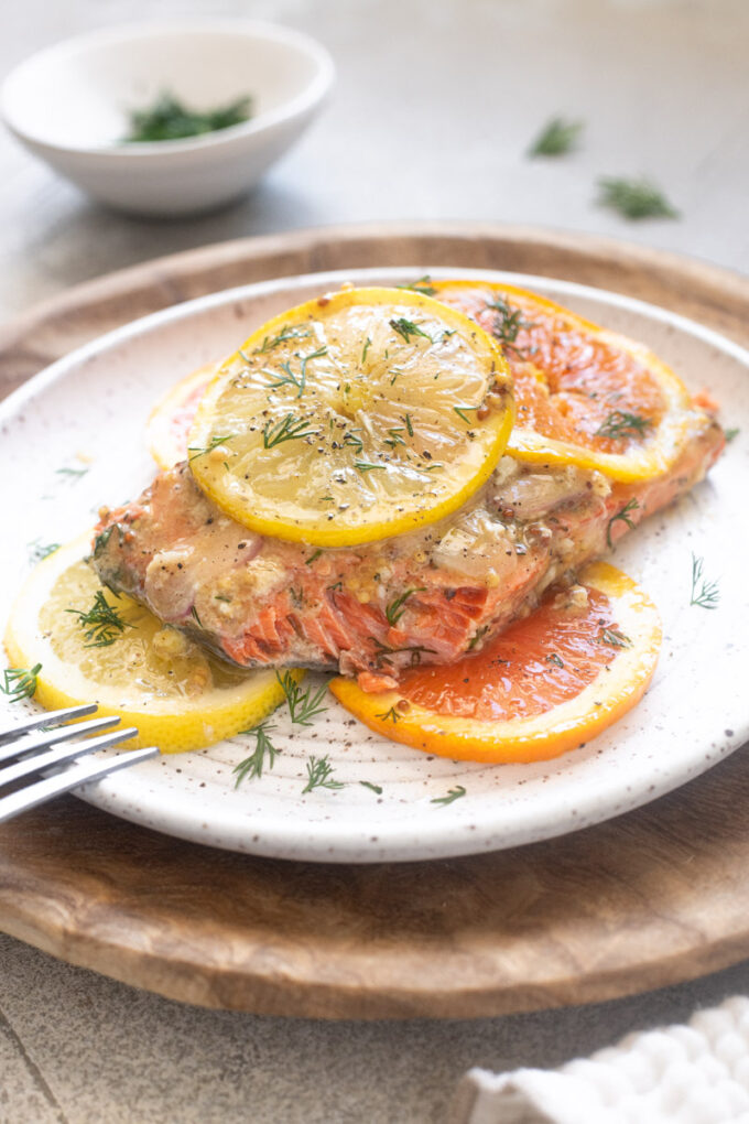 Close-up of flaky slow roasted salmon with citrus and dill.