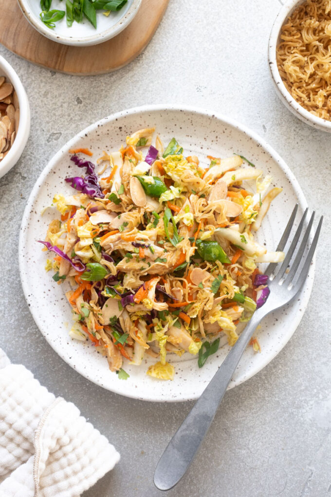 Asian chicken salad on a plate with a fork.