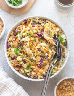 Chinese chicken salad in a bowl with serving spoons.