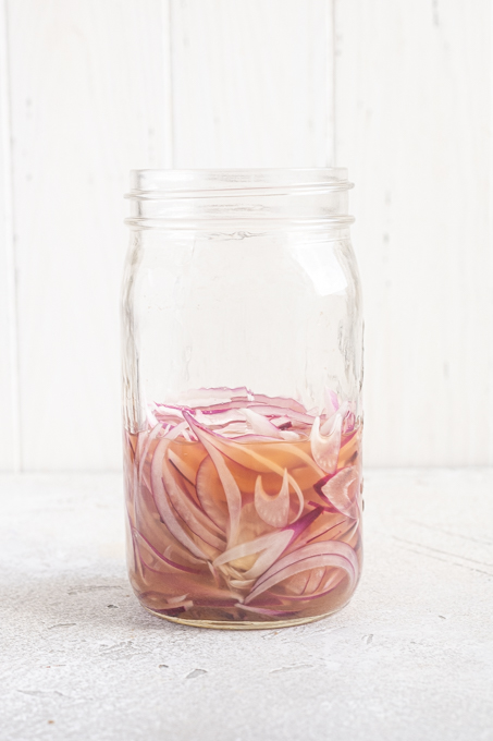 Jar of sliced red onions in brine.