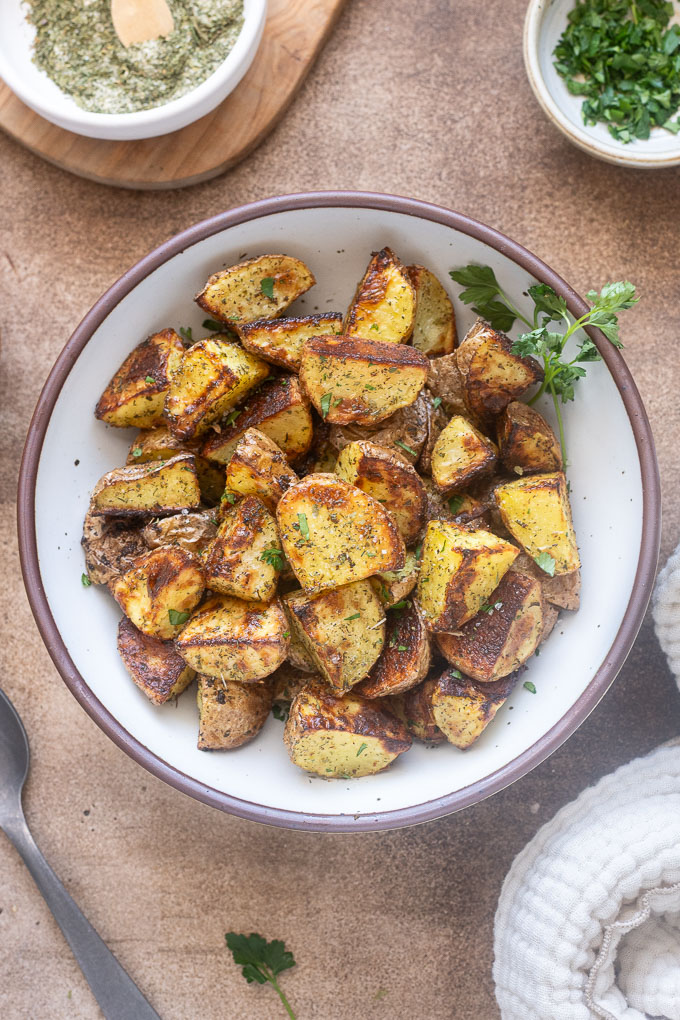 Ranch roasted potatoes in a bowl with parsley sprigs.