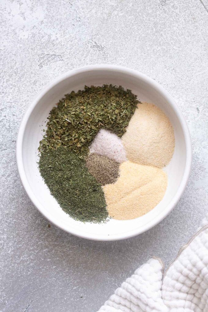 Ranch seasoning ingredients sectioned out in a white bowl.