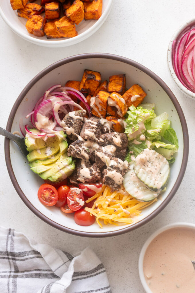 Easy burger bowls with cheese, roasted sweet potatoes and burger sauce.