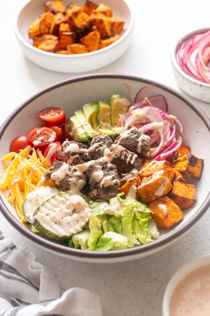 Easy burger bowls with sweet potatoes, pickled red onions and burger sauce.