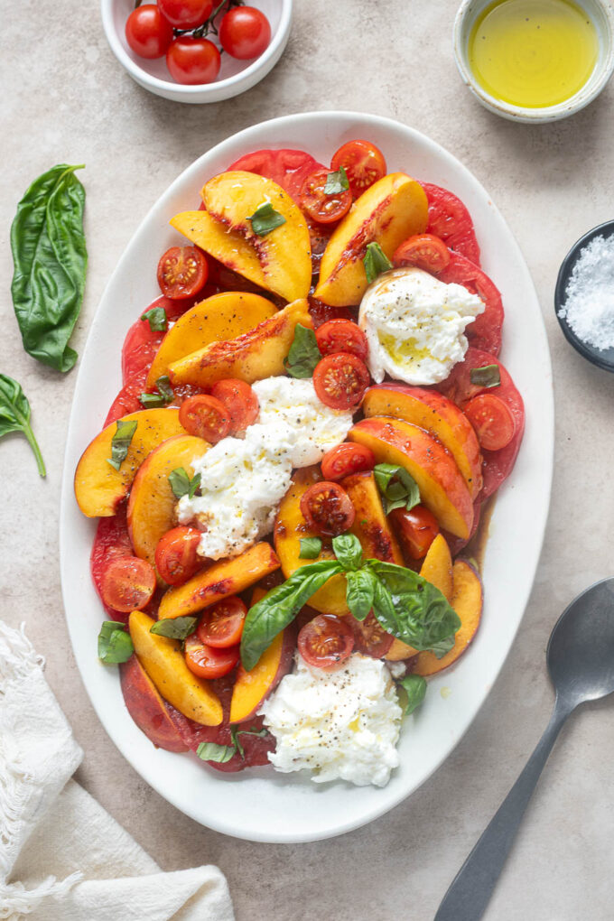 Burrata tomato peach salad with basil, olive oil and balsamic glaze.