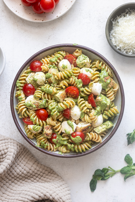 Finished chicken pesto pasta salad in mixing bowl.