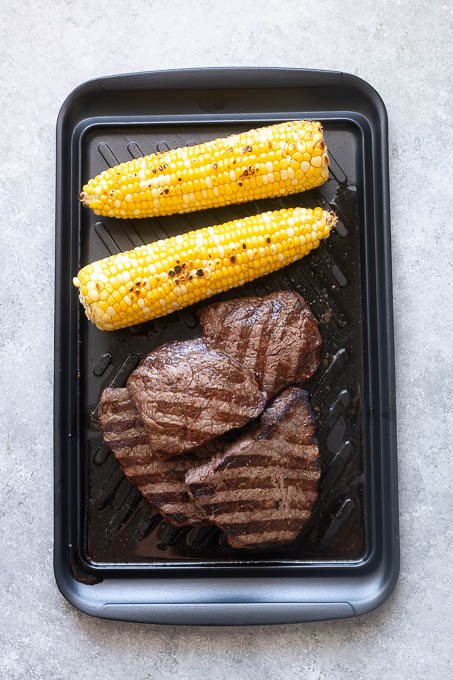 Grilled steaks and corn on the cob for grilled steak salad.