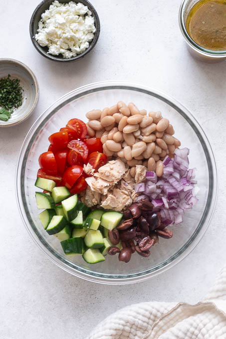 Tuna white bean salad recipe ingredients in a mixing bowl.