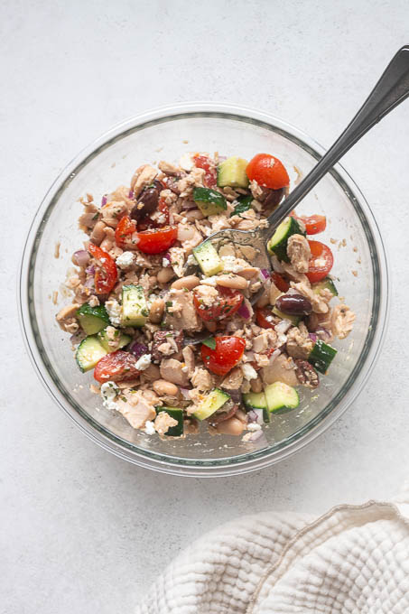 Dressed tuna white bean salad tossed in a mixing bowl.