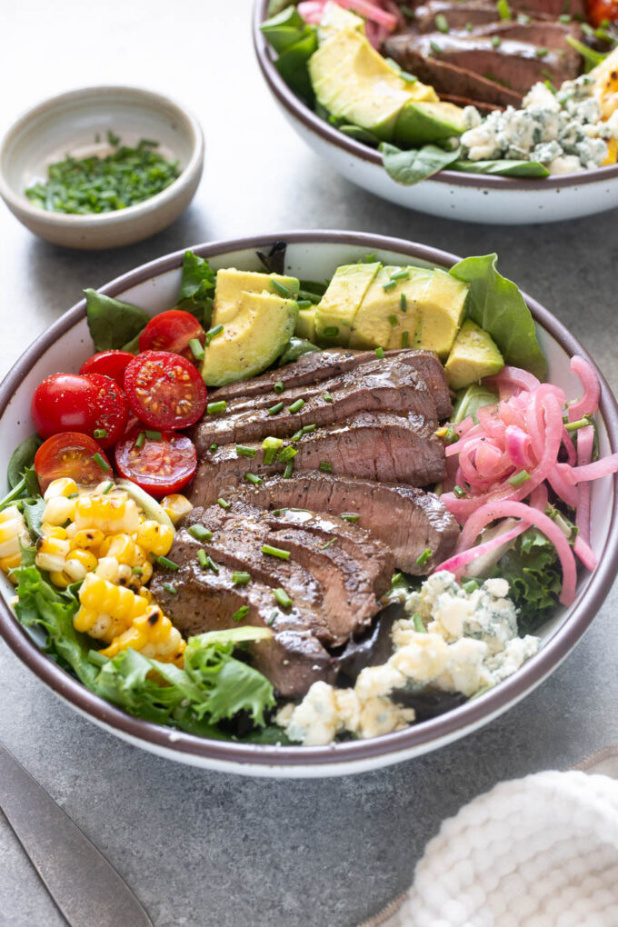 Grilled steak salad with sliced top sirloin, avocado, corn, tomatoes and blue cheese.