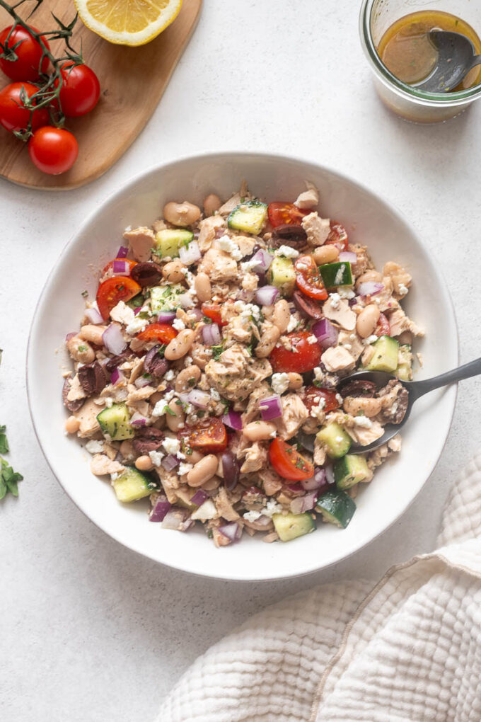 Overhead view of Mediterranean tuna white bean salad served in a white bowl.