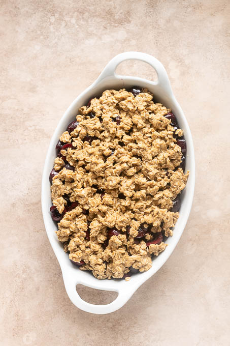 Unbaked cherry crisp with oat crumble topping.