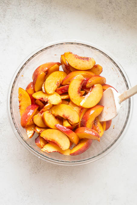 Fresh sliced peaches tossed with sugar and cornstarch for peach cobbler.