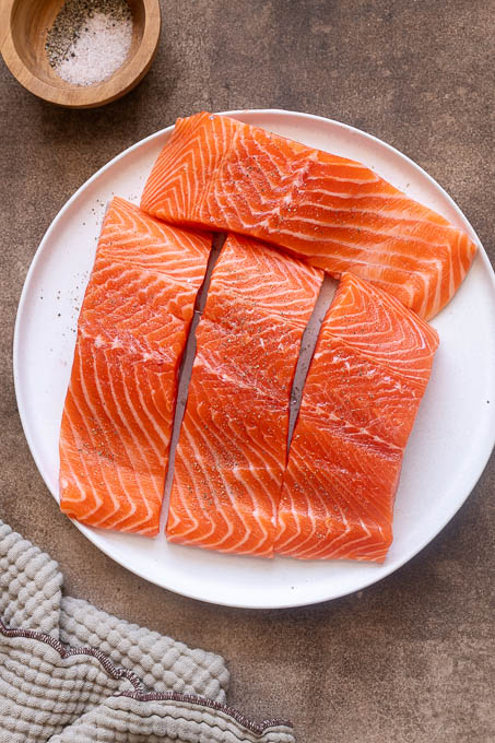 Salmon filets seasoned with salt and pepper.