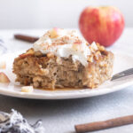 Apple cinnamon baked oatmeal on a plate topped with Greek yogurt.