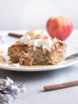 Apple cinnamon baked oatmeal on a plate topped with Greek yogurt.
