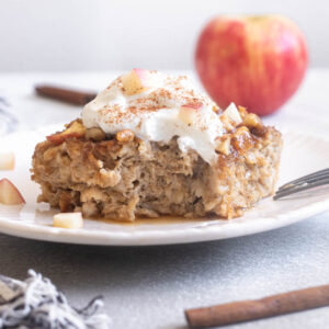 Apple cinnamon baked oatmeal on a plate topped with Greek yogurt.