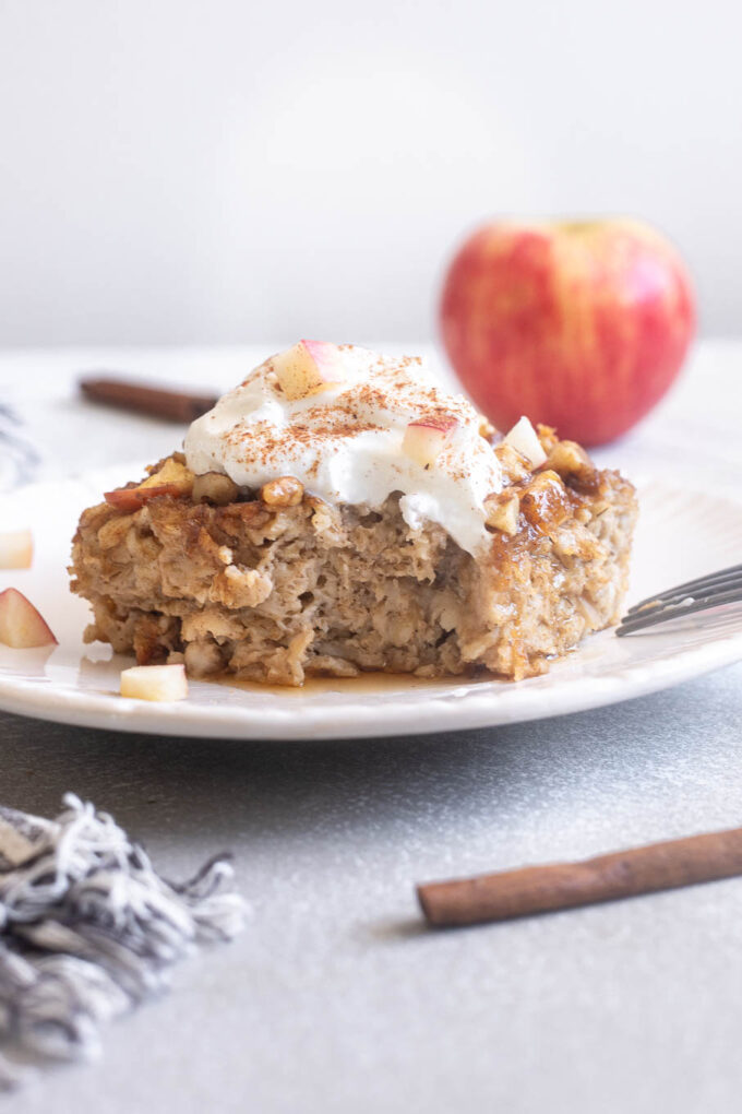 Apple cinnamon baked oatmeal on a plate topped with Greek yogurt.