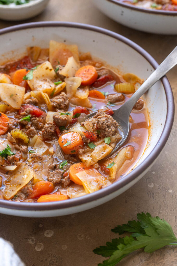 Close-up of cabbage and ground beef soup with carrots, tomatoes and tender cabbage in a savory broth.