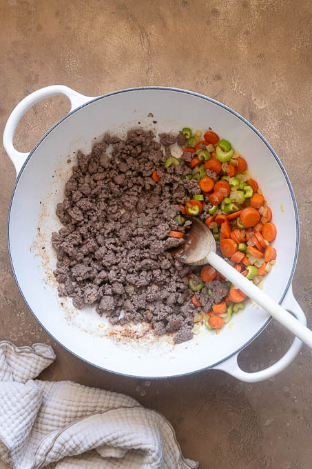 Browned ground beef and vegetables in Dutch oven.