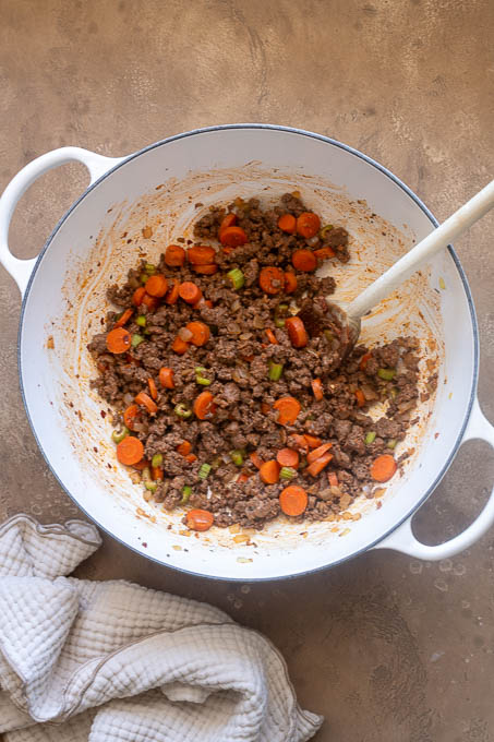 Beef, vegetables and tomato paste cooked in Dutch oven.