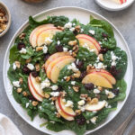 Spinach apple salad with walnuts, cranberries and feta cheese.