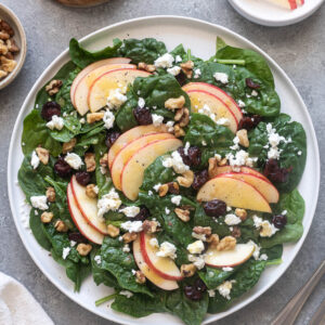 Spinach apple salad with walnuts, cranberries and feta cheese.