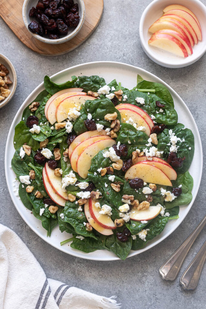 Spinach apple salad with walnuts, cranberries and feta cheese.