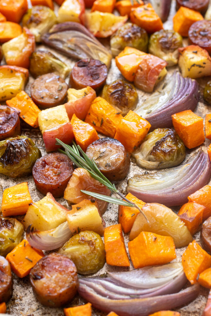 Roasted chicken apple sausage, Brussels sprouts, sweet potatoes, apples and shallots on a sheet pan.