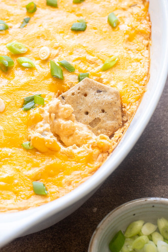 Cracker dipped into creamy buffalo chicken dip.